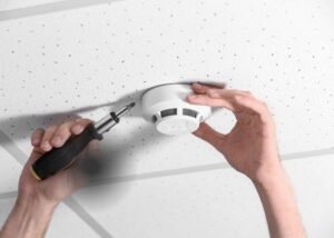 electrician installing smoke alarm