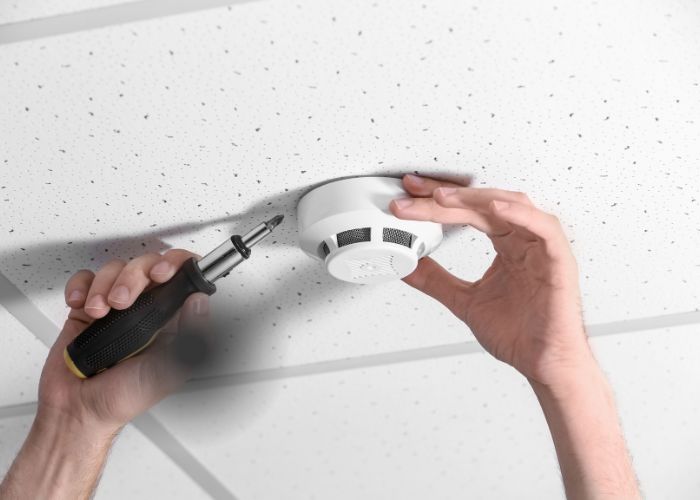 electrician installing smoke alarm